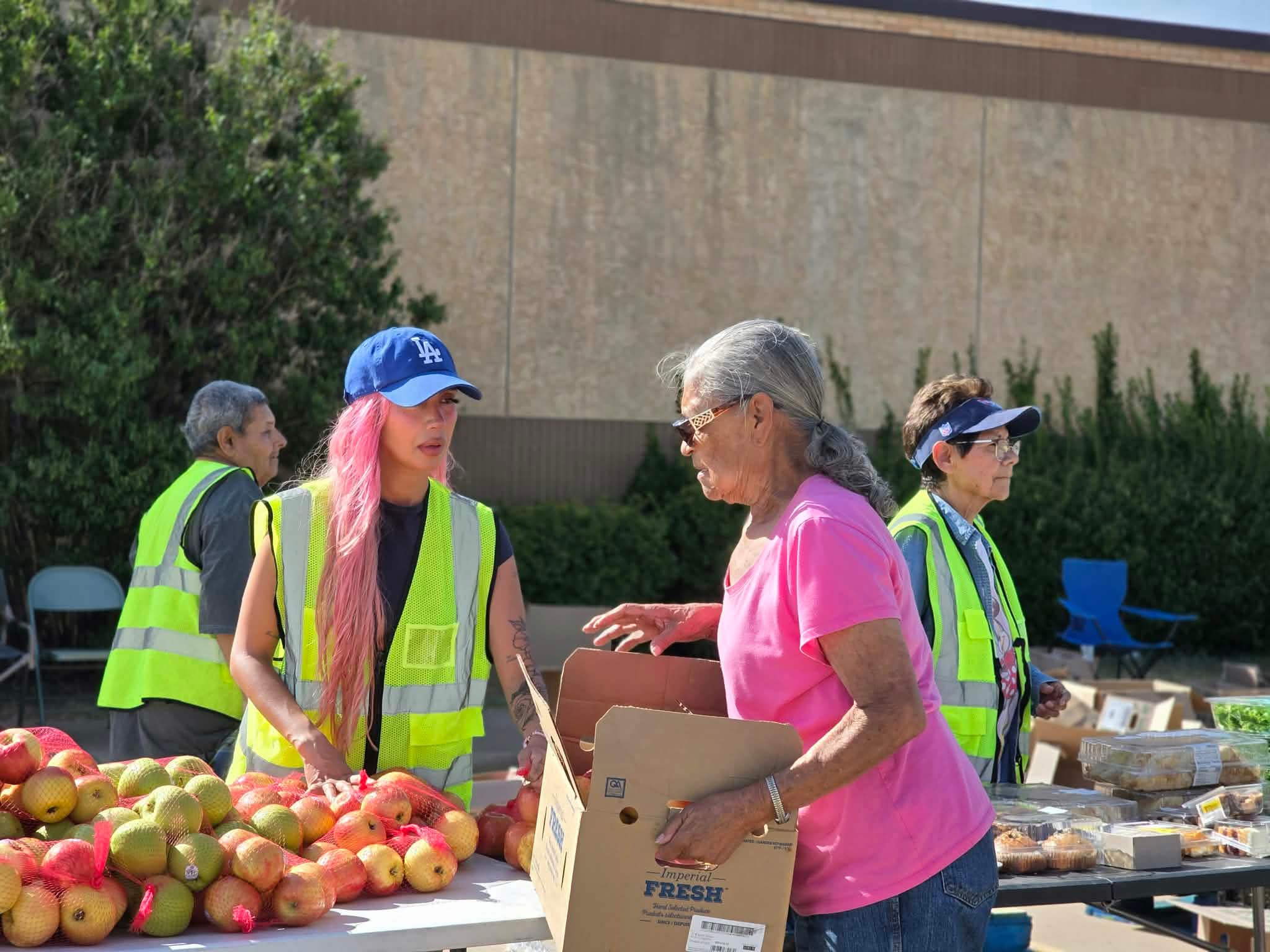 A volunteer helping a community member at the produce table