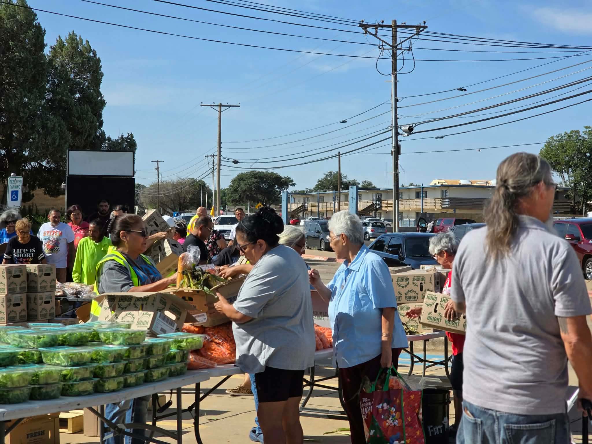 Volunteers and community members at the produce tables during the food giveaway